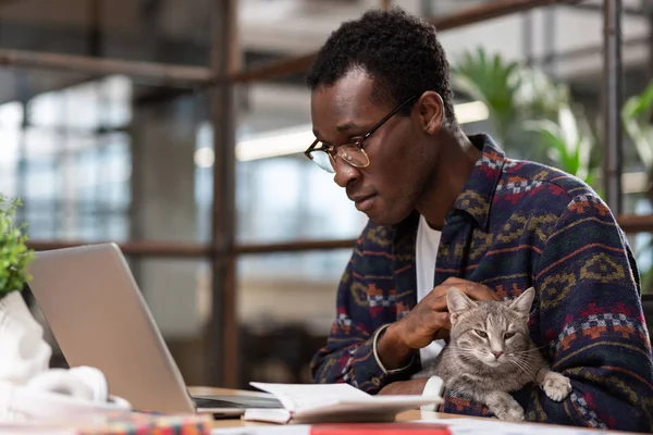 Hombre haciendo su trabajo junto con un gato — Foto de Stock