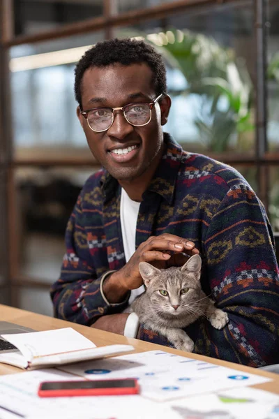 Homme caressant un chat de bureau tout en faisant une pause — Photo