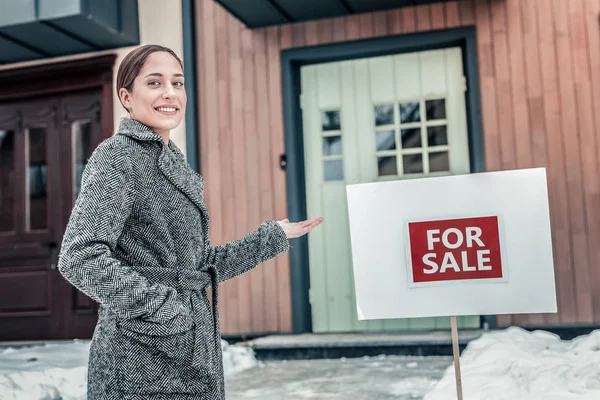 Agente imobiliário vestindo casaco quente em pé fora agradável casa grande — Fotografia de Stock