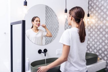 Çekici kadın tuvalette ayakta diş fırçalama