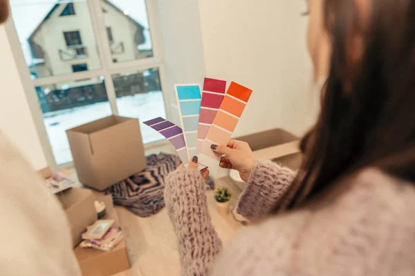 Woman wearing purple sweater holding papers with color variety — Stock Photo, Image