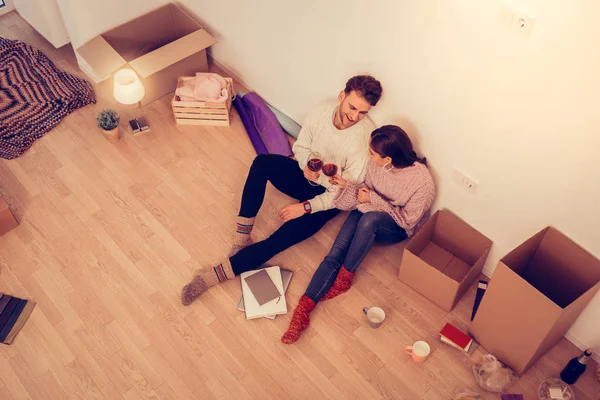 Pareja sentada en el suelo y bebiendo vino en un apartamento nuevo — Foto de Stock