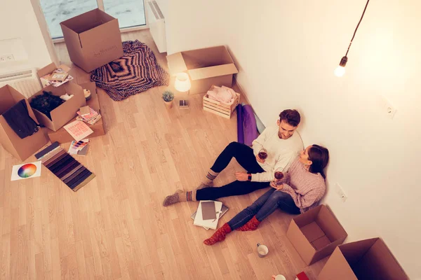 Ovanifrån av par som vilar i den tomma rum full av lådor — Stockfoto
