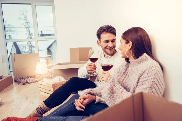 Loving husband holding hand of his wife tight while drinking wine — Stock Photo, Image