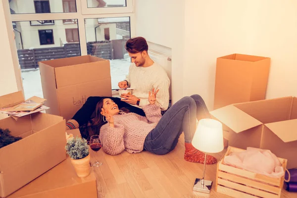Couple near the window in their new room full of boxes and stuff — Stock Photo, Image