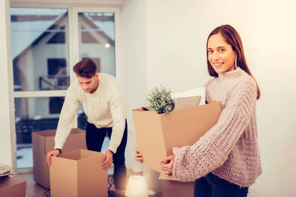 Fru hålla låda med växter medan du flyttar i nya hus — Stockfoto