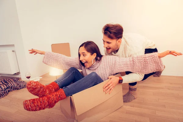 Couple going crazy after unpacking boxes with clothes — Stock Photo, Image