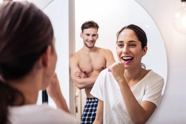 Žena se směje při čištění zubů a mluvil s manželem — Stock fotografie