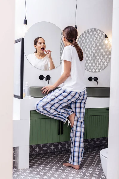 Mulher vestindo pijama baggy confortável escovando os dentes pela manhã — Fotografia de Stock