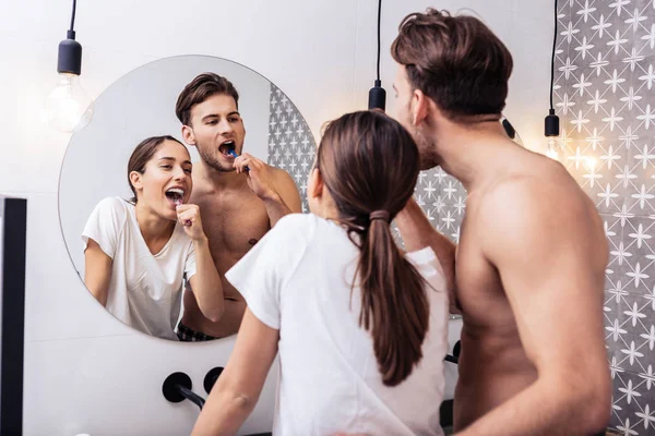 Man hugging his lovely wife while brushing teeth together — Stock Photo, Image