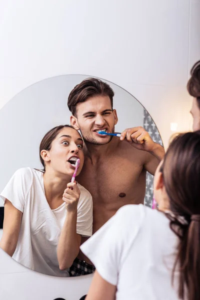 Пара чувствует себя веселыми и смешными, когда чистит зубы — стоковое фото
