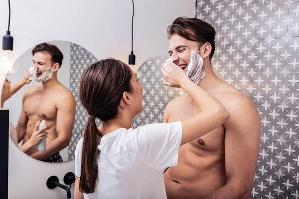 Esposa poniendo espuma de afeitar en su nariz de pie en el baño — Foto de Stock
