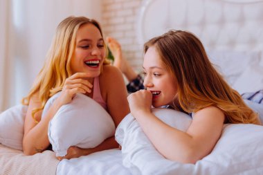 Kız yatakta yatan ve komik çocukluk hatırlayarak süre gülüyor