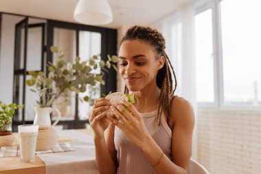 Egzersiz yaptıktan sonra sağlıklı sandviç yemeden önce heyecanlı hissediyorum kadın