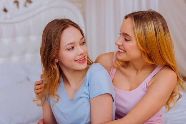 Liefdevolle ondersteunende jongere zus, haar mooie meisje knuffelen — Stockfoto
