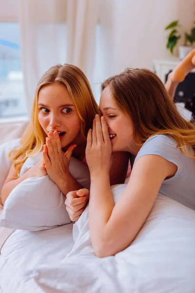 Surorile se răcesc în pat și își împărtășesc secretele unul cu celălalt — Fotografie, imagine de stoc