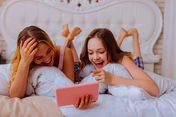 Irmãs rindo em voz alta depois de assistir vídeo engraçado — Fotografia de Stock