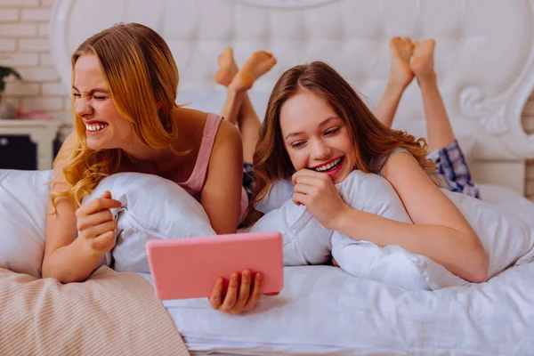 Irmãs rindo em voz alta depois de assistir comédia com irmãos — Fotografia de Stock