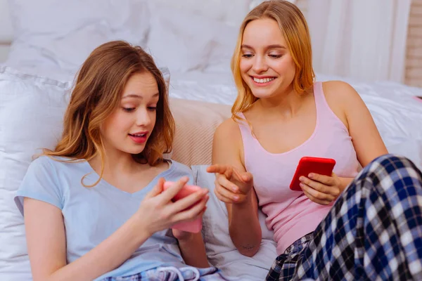 Два брата и сестры делают покупки онлайн в спальне вместе — стоковое фото