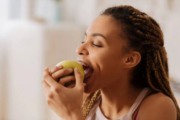 Krásná mladá žena kousání pěkné zelené jablko ráno — Stock fotografie