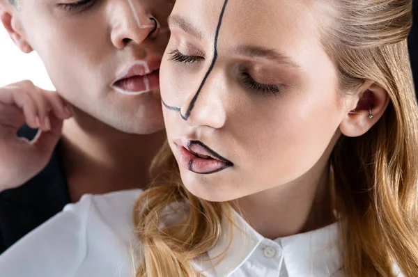 Модель с натуральным макияжем с черными линиями на лице — стоковое фото
