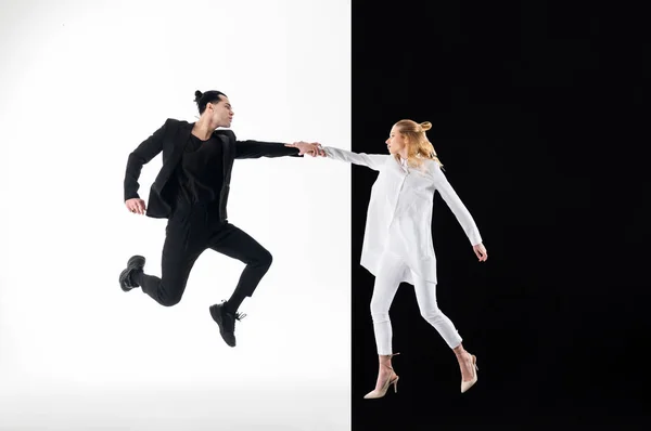 Hombre con traje negro saltando mientras posaba con una mujer joven — Foto de Stock