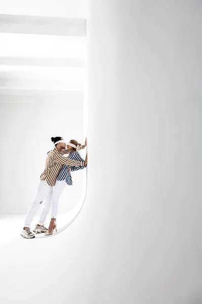 Dois modelos profissionais posando para a promoção da marca na sala branca — Fotografia de Stock