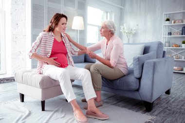 Kadın onun karnında bazı ağrı varken endişeli duygu