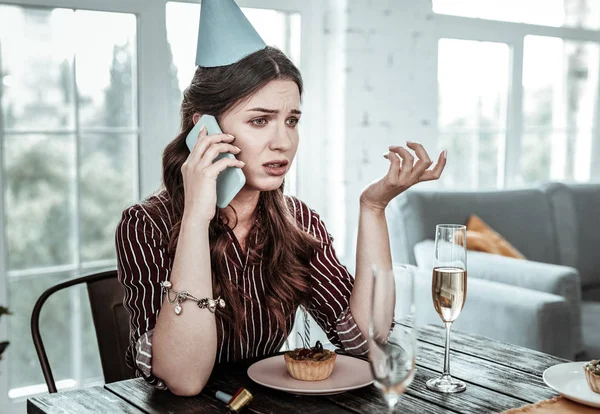 Sad woman talking on the phone on her birthday — Stock Photo, Image