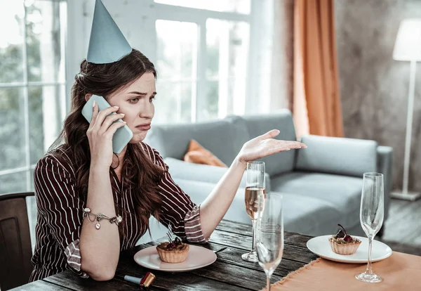 Upprörd kvinna pratar i telefon på hennes födelsedag — Stockfoto