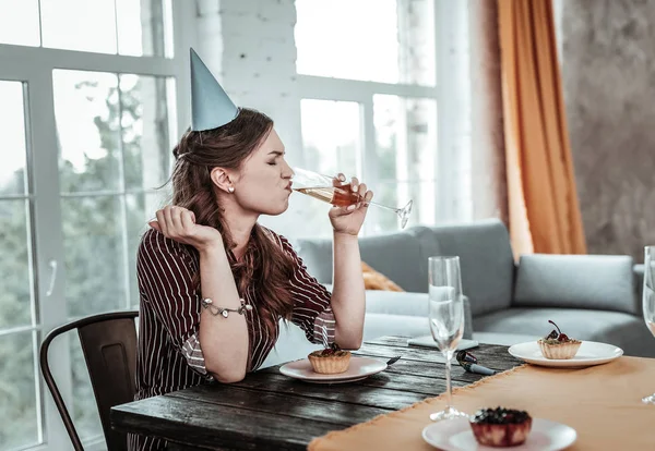 Woman drinking the champagne alone at her birthday party