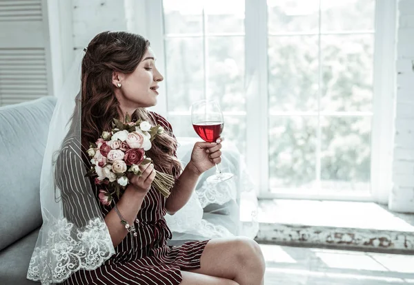 Woman wearing a wedding veil drinking wine — Stock Photo, Image