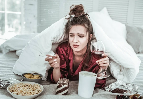 Mujer joven deprimida comiendo mucho sola — Foto de Stock