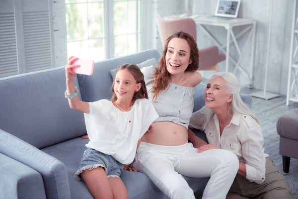 Nettes Mädchen macht Selfie mit schwangerer Mutter und Großmutter — Stockfoto