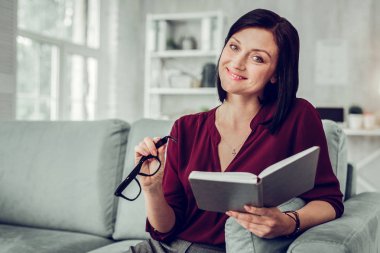 Pleasant family therapist wearing dark red blouse smiling broadly