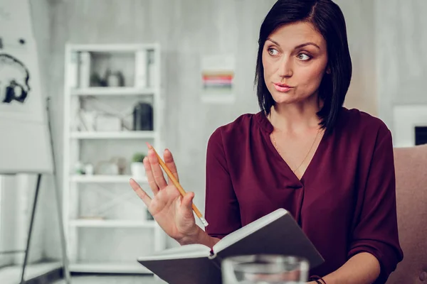 Familj terapeut lugnande klient ner medan du håller penna i handen — Stockfoto