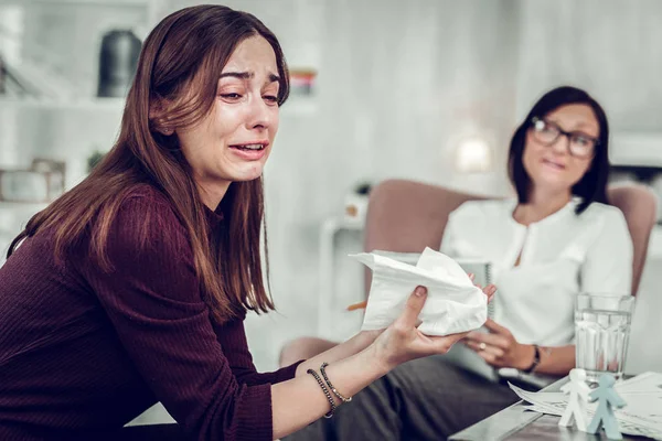 Frau hält Servietten, während sie weint und ihre Gefühle teilt — Stockfoto