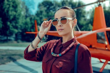 Mücevher varken büyük güneş gözlüğü alarak ciddi çekici kadın