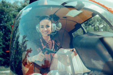 Ön koltukta oturan neşeli koyu saçlı profesyonel pilot