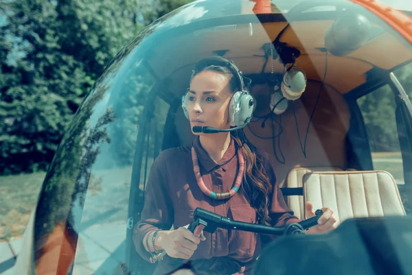 Piloto feminino concentrado e bem-parecido usando equipamentos necessários — Fotografia de Stock