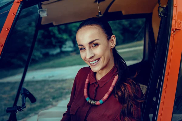 Mörkhårig attraktiv kvinna med ljusa smycken vistas i helikopter — Stockfoto