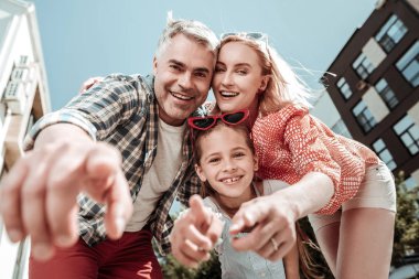 Fotoğraf makinesine işaret eden mutlu bir adam