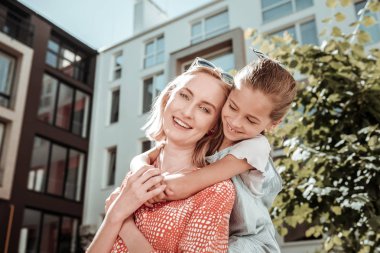 Neşeli güzel kız onu sevgili anne sarılmak