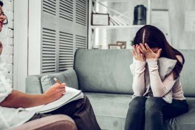 Siyah saçlı Genç kadın psikiyatrist yüzünü gizleme