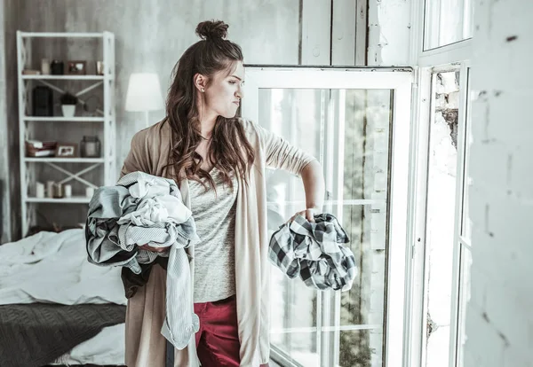 Angry woman throwing the shirts of her ex away — Stock Photo, Image