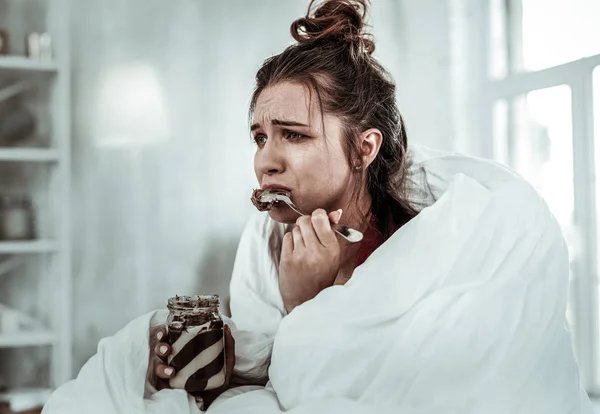 Woman eating chocolate pasta because of being stressed — Stock Photo, Image