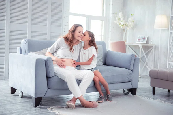 Ragazza baciare la sua mamma incinta, mentre trascorrere del tempo insieme — Foto Stock