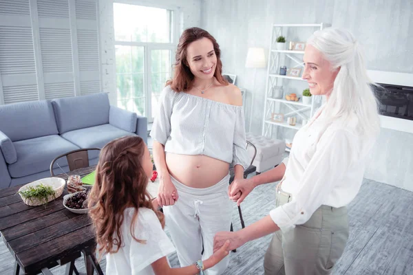 Donna incinta che si tiene per mano della sua mamma e figlia carina — Foto Stock