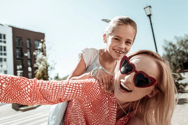 Encantada jovem positiva segurando sua filha — Fotografia de Stock