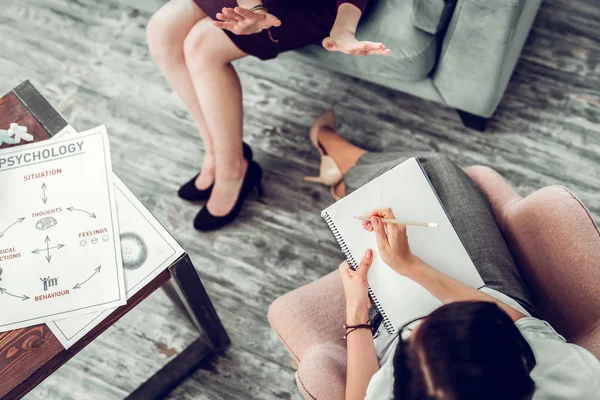 Terapeuta vistiendo pantalones hablando de sentimientos y comportamiento — Foto de Stock